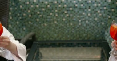 Spa salonunda tropikal kokteyl içen iki rahat kız.