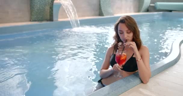 Vrouw met glas cocktail genietend van wellness en spa zwemmen — Stockvideo