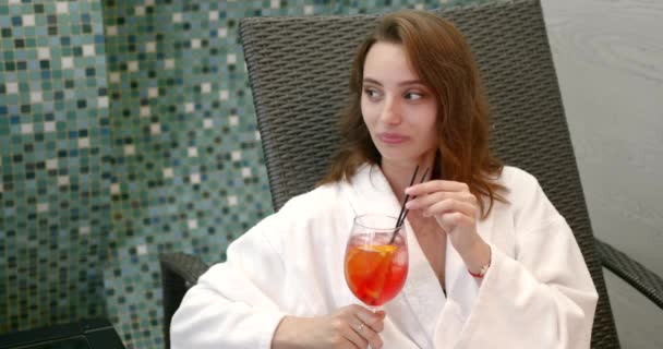 バスローブの女性はスパリゾートでカクテルを楽しむ — ストック動画
