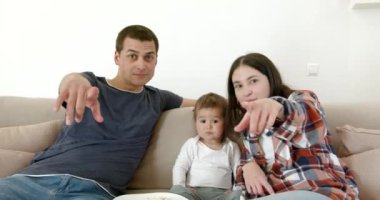 Evde film izleyen çocuklu bir aile.