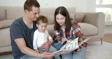 Çocuk kitabı okuyan küçük mutlu bir aile.