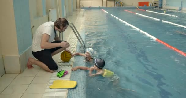 Instructor masculino enseña a los niños a nadar — Vídeos de Stock