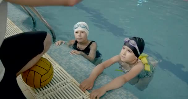 Instructor masculino enseña a los niños a nadar — Vídeo de stock