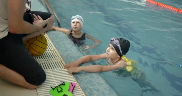 Muž instruktor učí děti, jak plavat — Stock video