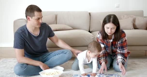 Молода щаслива сім'я з маленькою дівчинкою читає дитячу книгу — стокове відео
