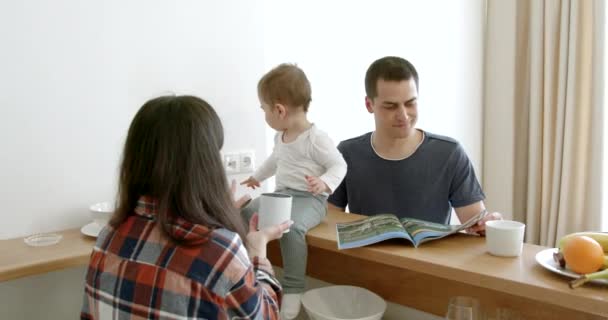 Junge süße Familie mit kleiner Tochter frühstückt — Stockvideo