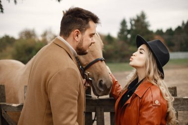 Çiftlikte kahverengi atlı romantik bir çift.