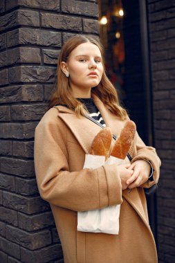 Caddede elinde baget tutan kırmızı dudaklı kız, kese kağıdıdır.