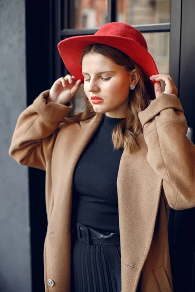 Портрет дівчини з червоним капелюхом, що стоїть біля тераси відкритого кафе — стокове фото