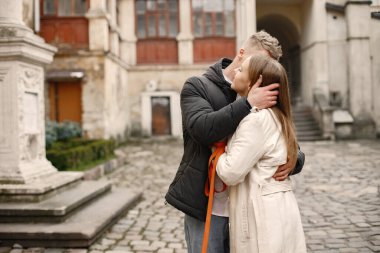 Romantik çift eski şehrin sokaklarında sarılıp öpüşüyor.