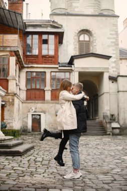 Romantik çift eski şehrin sokaklarında sarılıp öpüşüyor.