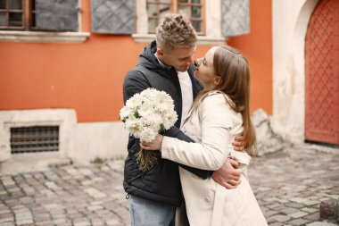 Romantik çift eski şehrin sokaklarında sarılıp öpüşüyor.