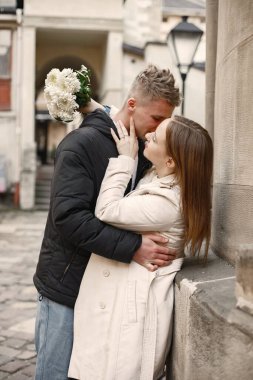Romantik çift eski şehrin sokaklarında sarılıp öpüşüyor.