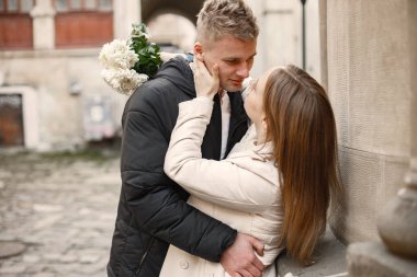 Romantik çift eski şehrin sokaklarında sarılıp öpüşüyor.