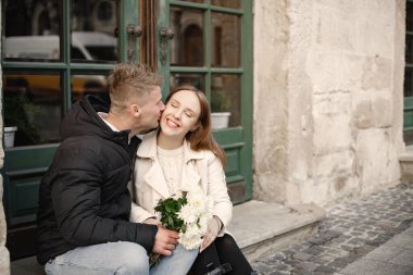 Romantik çift eski şehrin sokaklarında sarılıp öpüşüyor.