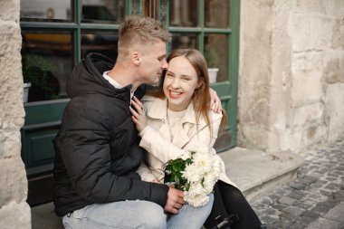 Romantik çift eski şehrin sokaklarında sarılıp öpüşüyor.