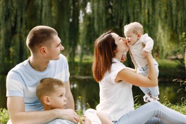 Mutlu aile göl kenarındaki parkta piknik yapıyor.
