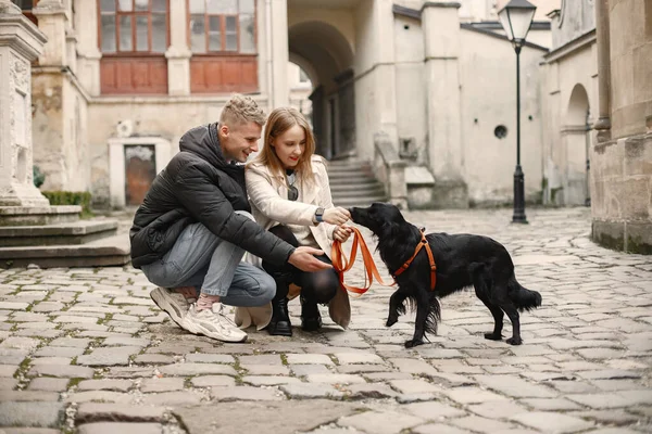 Preciosa pareja acariciando a su perro en la calle del casco antiguo — Foto de Stock