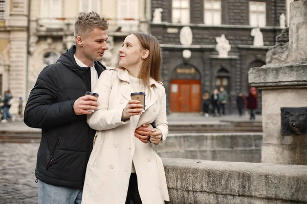 古い町の通りを歩いている間にテイクアウトコーヒーを持ってロマンチックなカップル — ストック写真