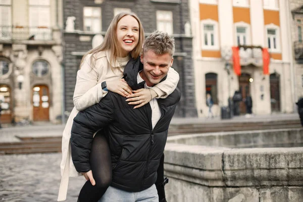 旧市街の通りを歩きながら、ロマンチックなカップルが抱きついています — ストック写真