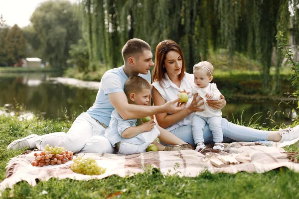 Famiglia felice fare un picnic nel parco vicino al lago — Foto Stock