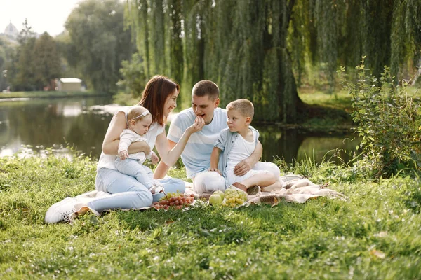 Bonne famille ont un pique-nique dans le parc près du lac — Photo