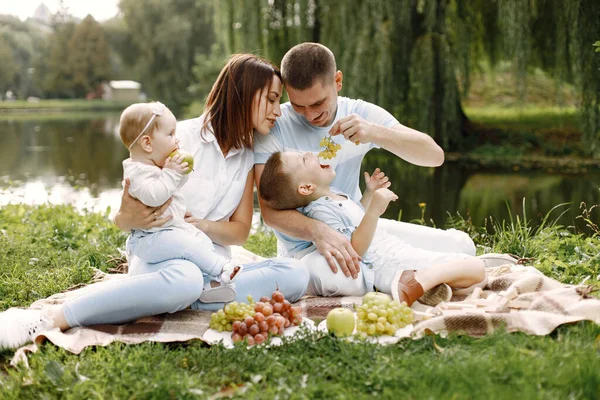 Glückliche Familie picknickt im Park am See — Stockfoto