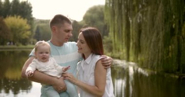Ailesi ve bebeği parktaki nehrin kenarında.