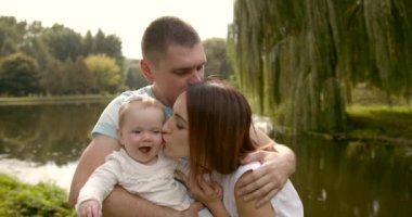 Mutlu ebeveynler ve küçük kız parkta nehir kenarında
