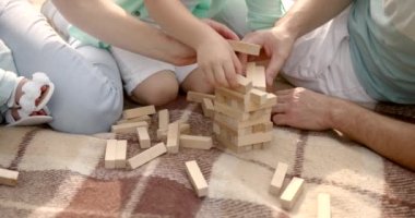 Genç bir aile nehirde ekoseyle Jenga oynuyor.