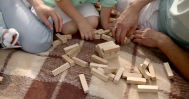 Genç bir aile nehirde ekoseyle Jenga oynuyor.