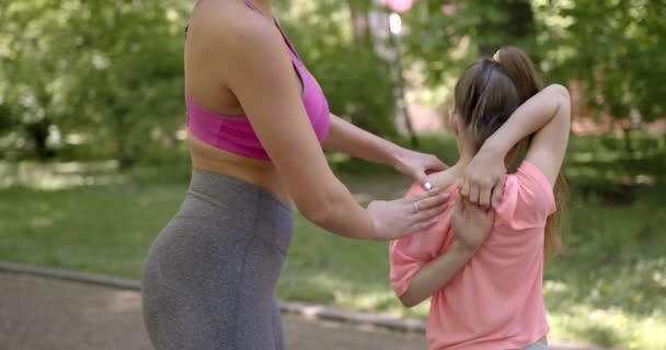 Mor hjälper dottern att hålla armarna låsta — Stockvideo