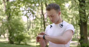 Parkta akıllı adam kullanan atletik bir adam