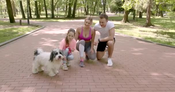 Sportovní rodina procházky se psem v parku — Stock video