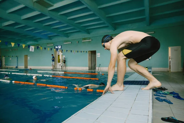 Manlig simmare hoppar i en pool — Stockfoto