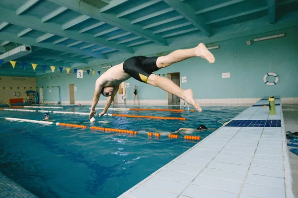 男子游泳运动员在游泳池里跳跃 — 图库照片