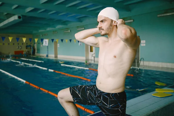 En professionell simmare sätter på sig en mössa — Stockfoto
