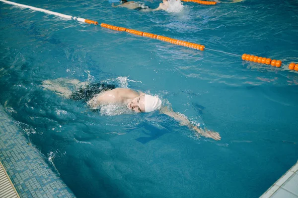 Professionell man simmare inomhus simbassäng — Stockfoto