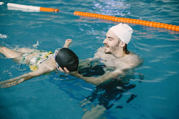 Flicka lära sig simma med tränare på fritidscenter — Stockfoto