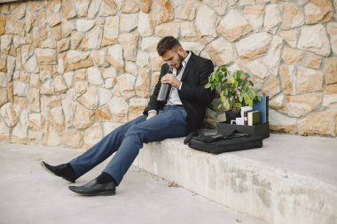 European employee got fired. He drinks alcohol from bottle.