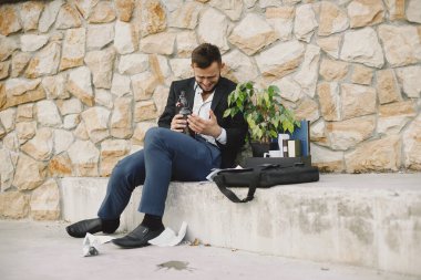 European employee got fired. He drinks alcohol from bottle.