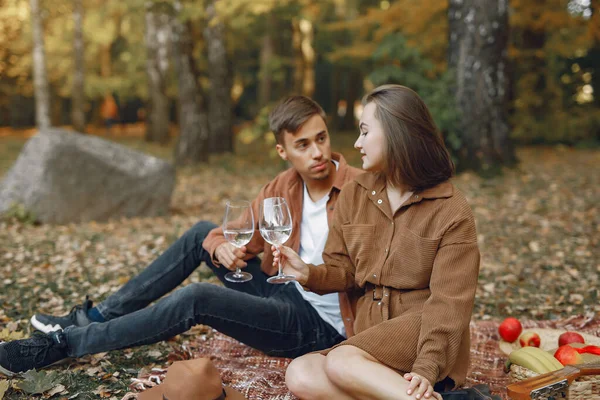 Couple in a park. Guy in a brown shirt. Golden autumn.