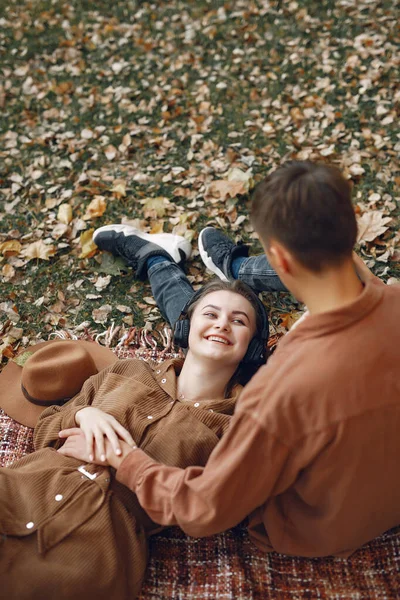 Couple in a park. Guy in a brown shirt. Golden autumn.