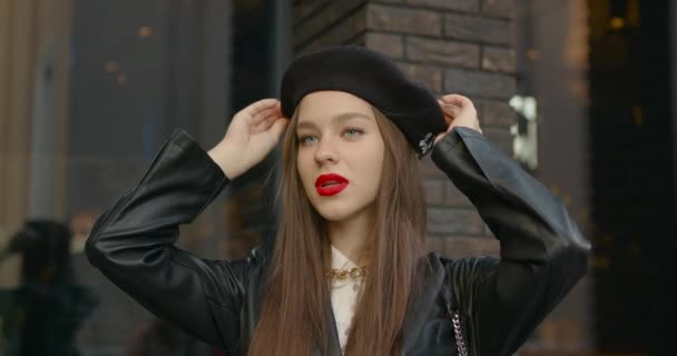 クローズアップビュー 黒ベレー帽の若い女性 レンガ造りの建物の近くの通りに立ち — ストック動画