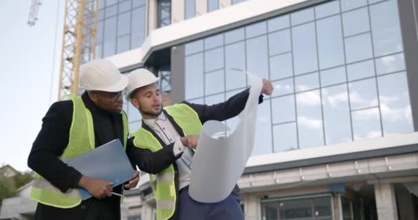 Los Trabajadores Uniforme Cascos Comparan Plan Construcción Cerca Del Nuevo — Vídeos de Stock