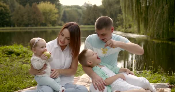 Szczęśliwa Rodzina Owoce Nad Stawem Rodzice Się Przytulają Trzymają Dzieci — Wideo stockowe