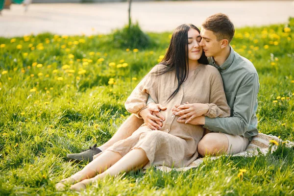 Couple Waiting First Baby Sitting Grass Hugging Pregnant Woman Her —  Fotos de Stock
