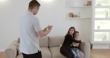 Kızgın koca karısını ve kızını evde tehdit ediyor. Zorbalık, taciz..
