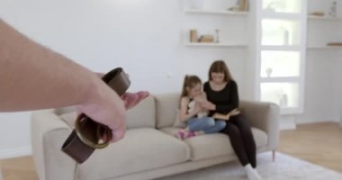 Cropped view of father with belt going to fight with wife and daughter. Mother embracing the scared child.