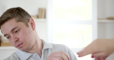 Mutsuz genç çift tartışıyor, gücenmiş kadın erkeği itiyor. Evde aile içi çatışma, kötü evlilik ilişkileri kavramı..